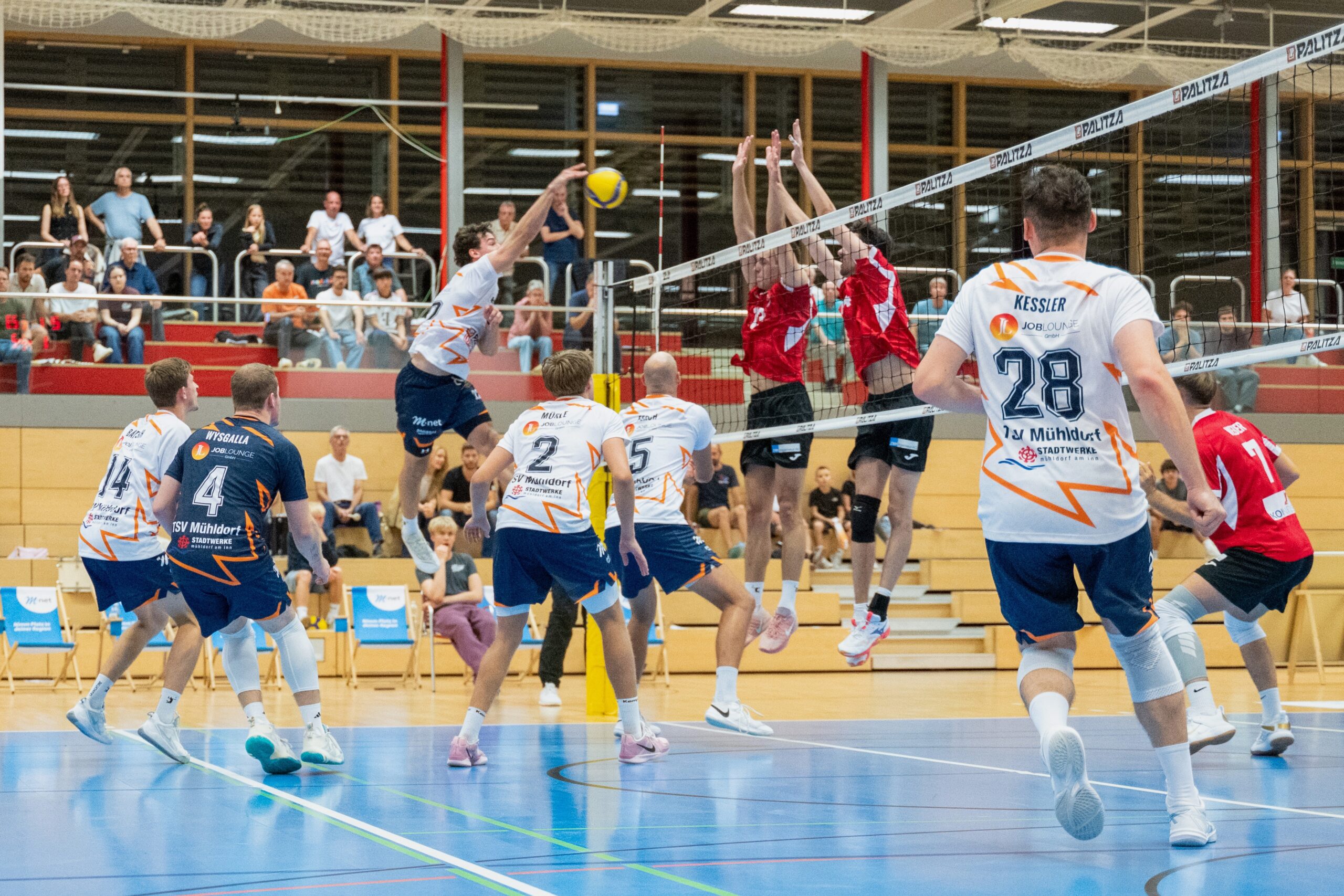 Foto (Matthias Hergenhan): Tom Schlösser im Angriff, machte eine starke Partie für die Mühldorfer. Allerdings war der Kriftler Diagonalspieler Pascal Eichler, hier im Block links, an diesem Samstag zu gut.
